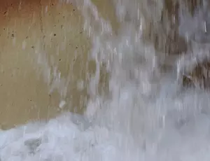 Close-up of water cascading down a concrete surface, illustrating controlled water flow & drainage infrastructure