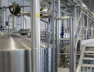 Stainless steel tanks and metal walkway in an industrial wastewater treatment facility