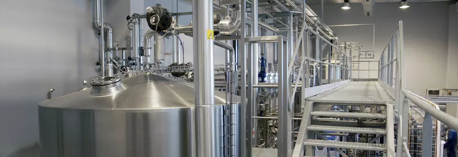 Stainless steel tanks and metal walkway in an industrial wastewater treatment facility