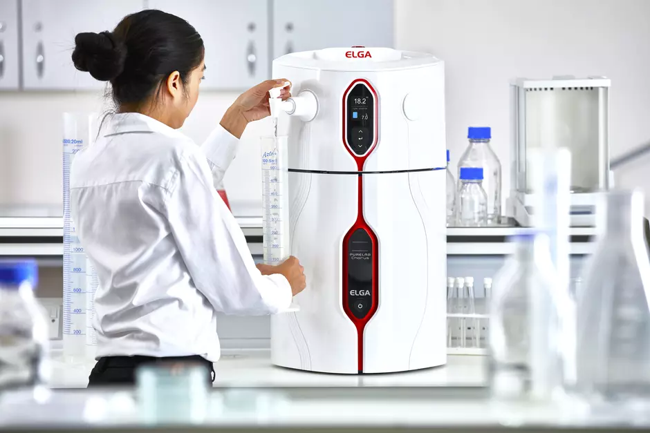 A girl dispensing water from the ELGA lab dispenser into a measuring cylinder